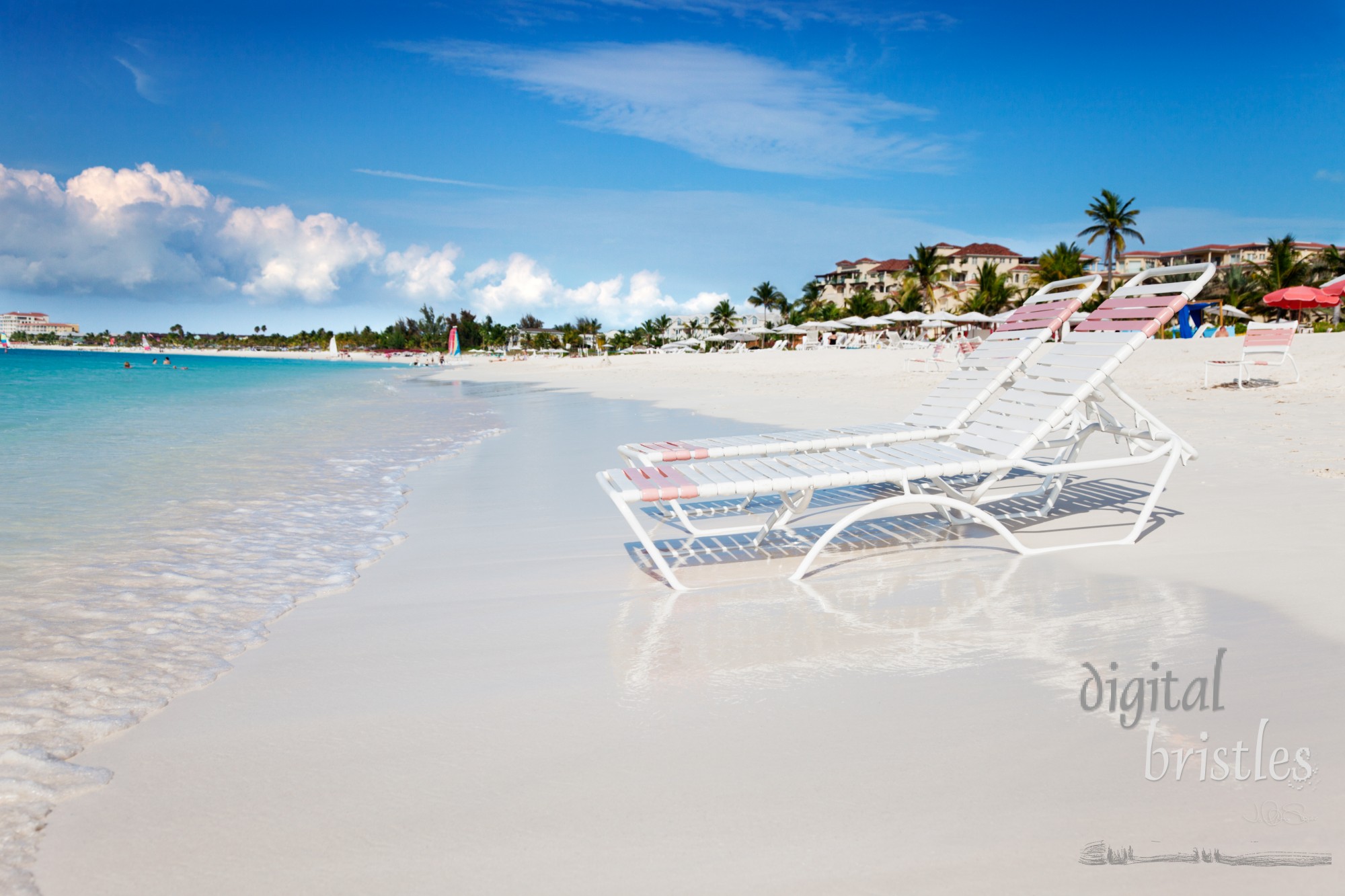 Beach chaises at water's edge on the soft white sands of Grace Bay Beach, Turks & Caicos