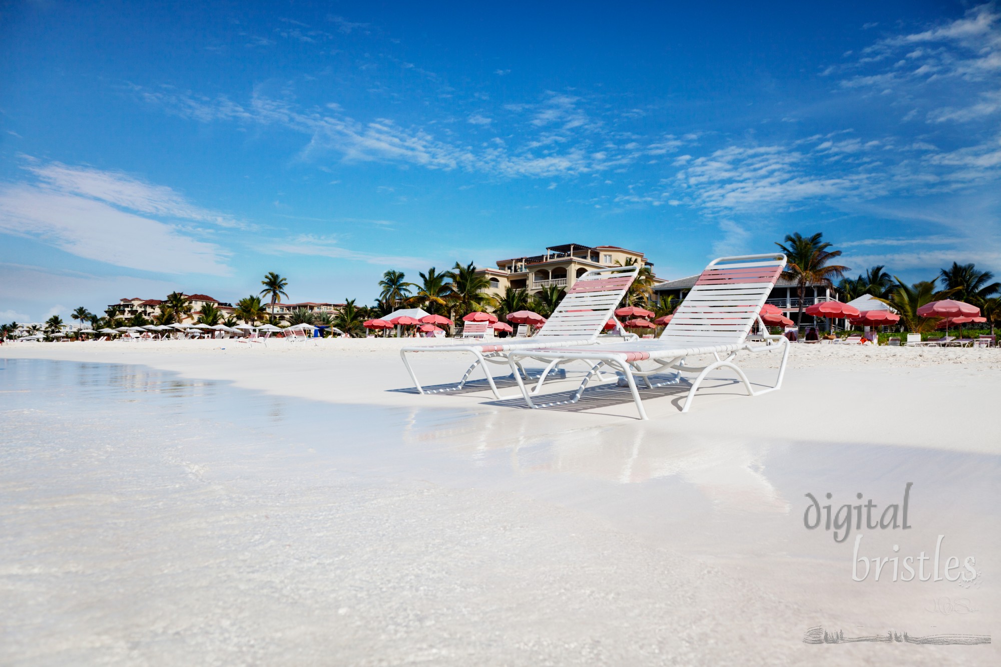 Beach chaises at water's edge on the soft white sands of Grace Bay Beach, Turks & Caicos