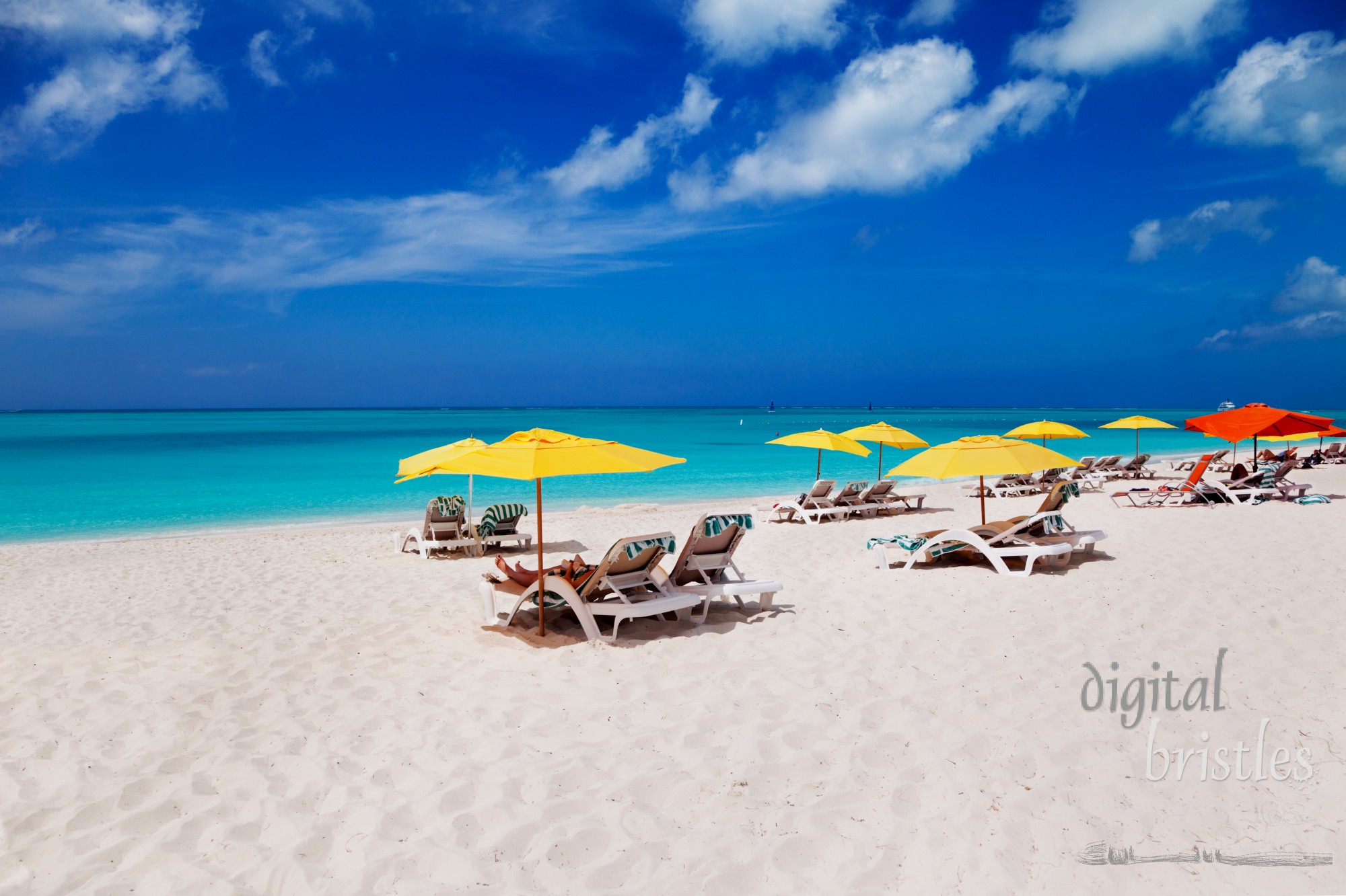 Vivid blues with  white sands of Grace Bay Beach, Turks & Caicos, and bright yellow beach umbrellas