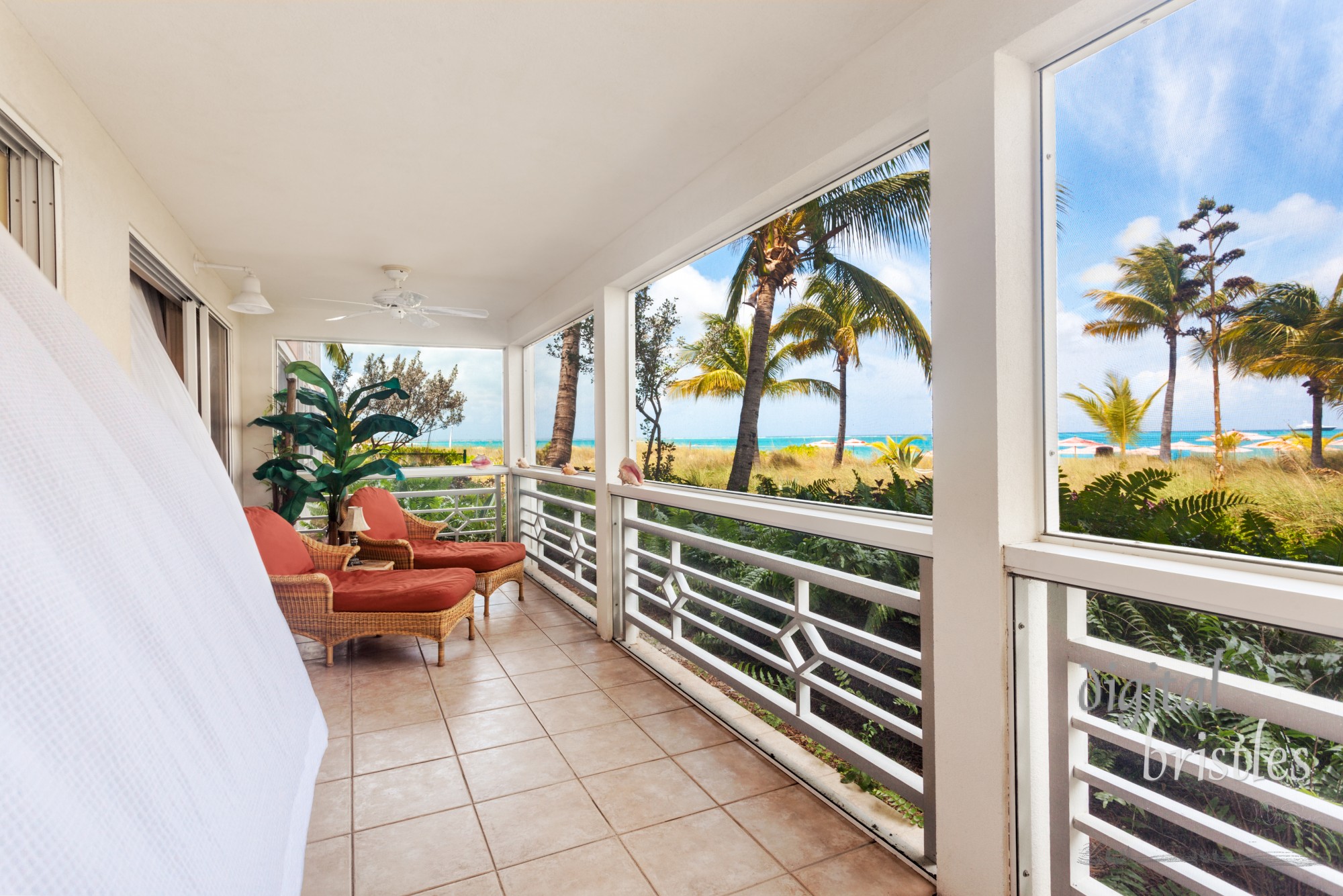 Billowing white curtains on a sunny screen in porch with an oceanfront view