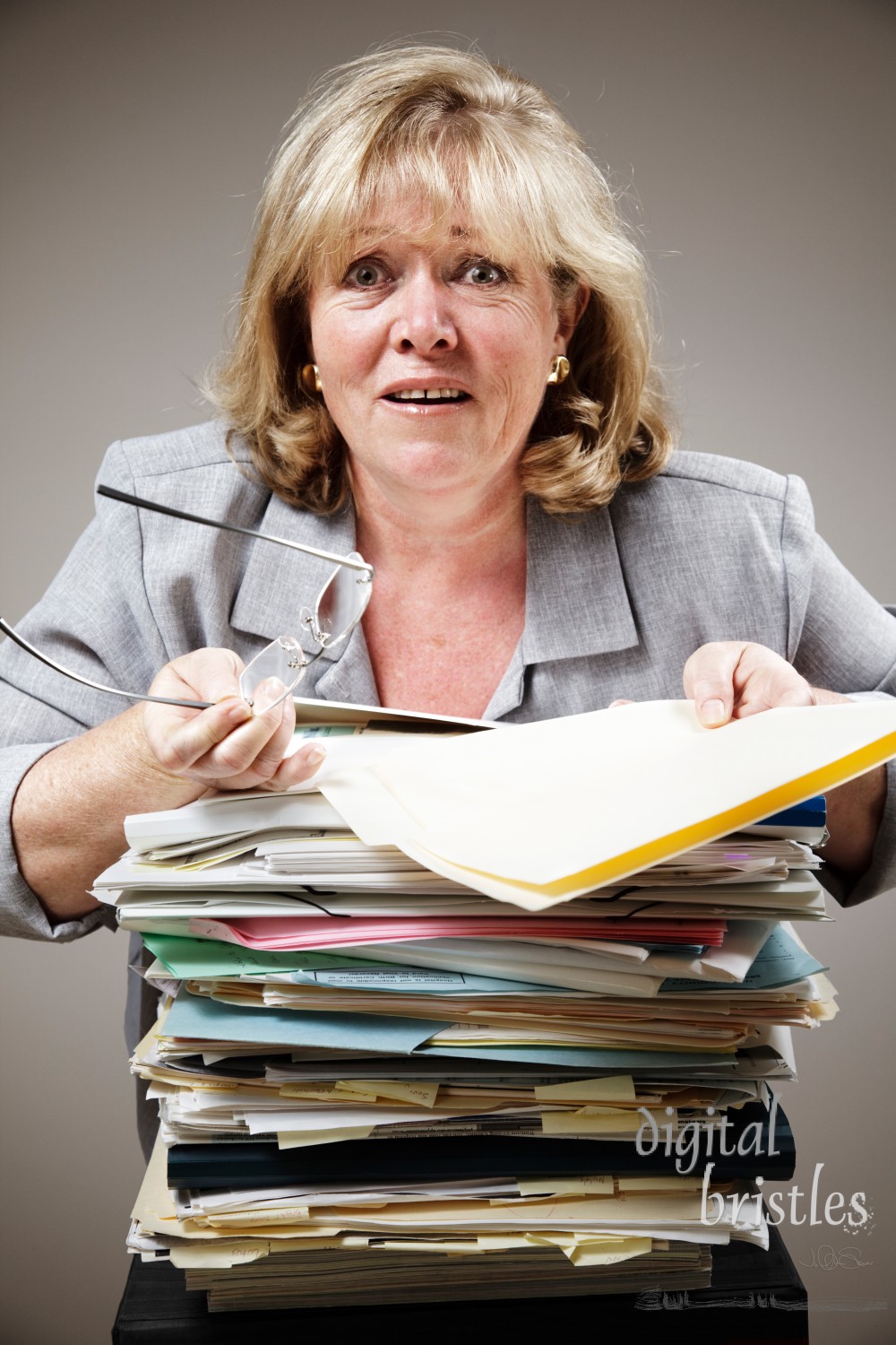 Mature woman overwhelmed by the stack of paperwork